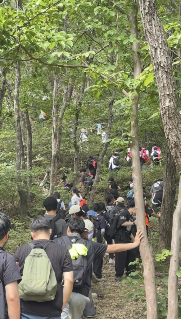 지리산 정상으로 가는 경사를 함께 오르는 학생들