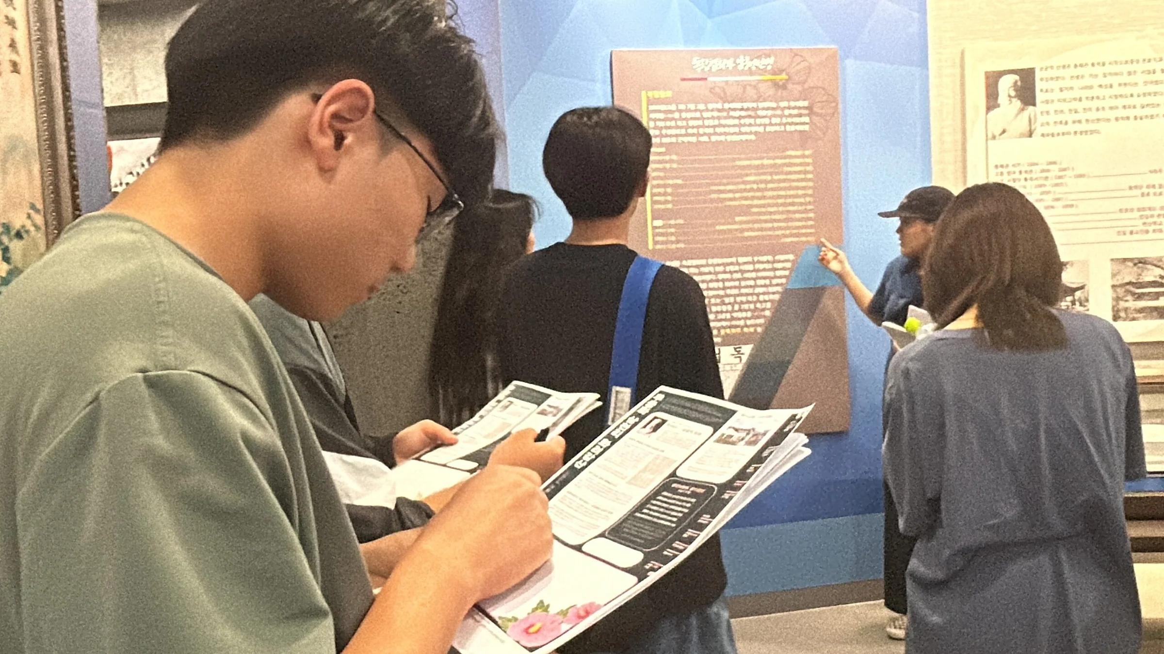 전시를 보며 기록하는 학생